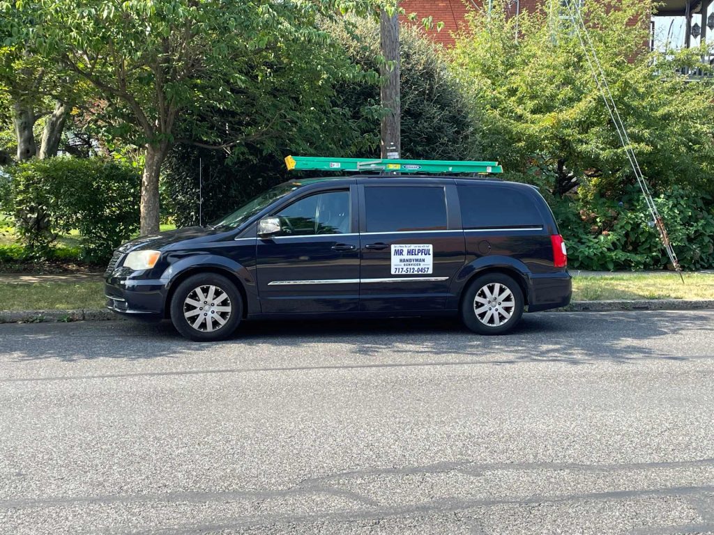 A dark van that has the word Mr. Helpful, LLC on the side.